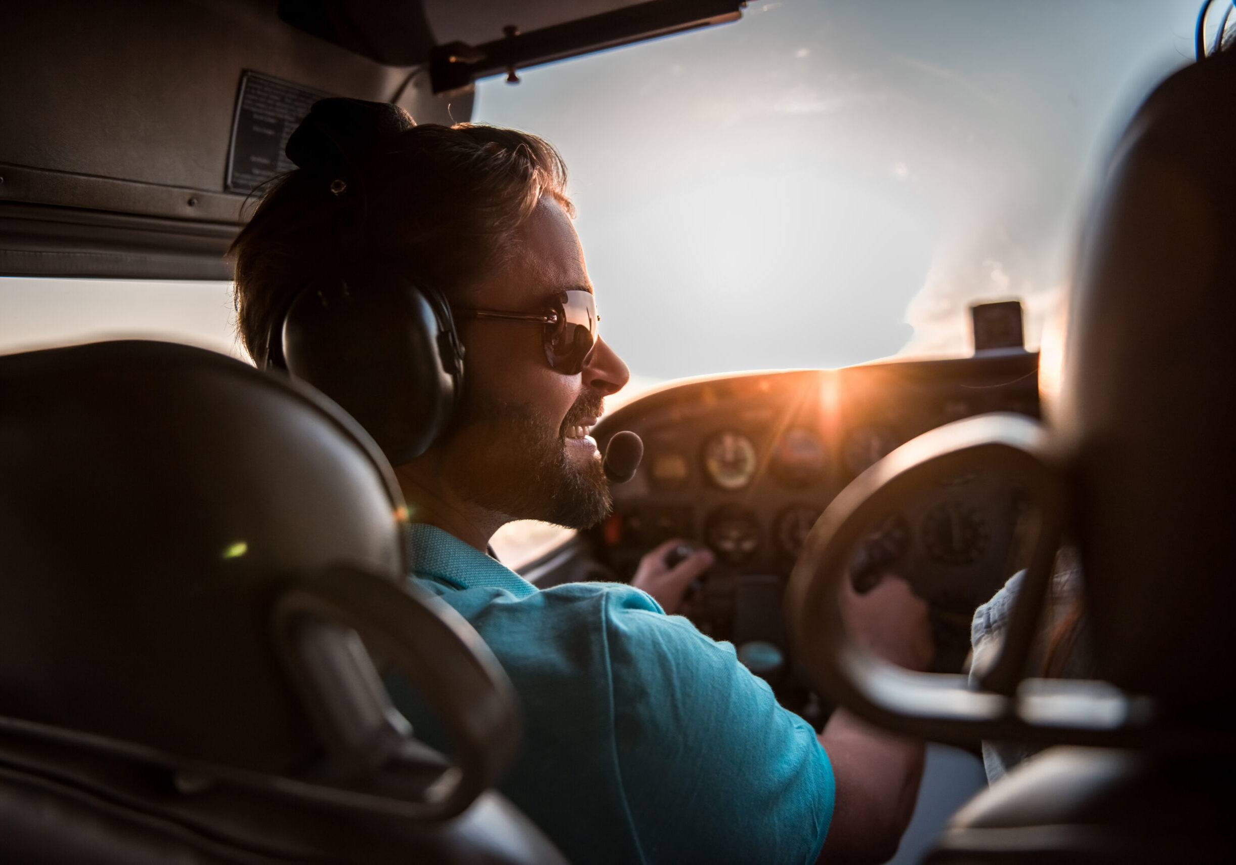 Back view from the inside of the plane, couple in aviation headsets is ready to fly