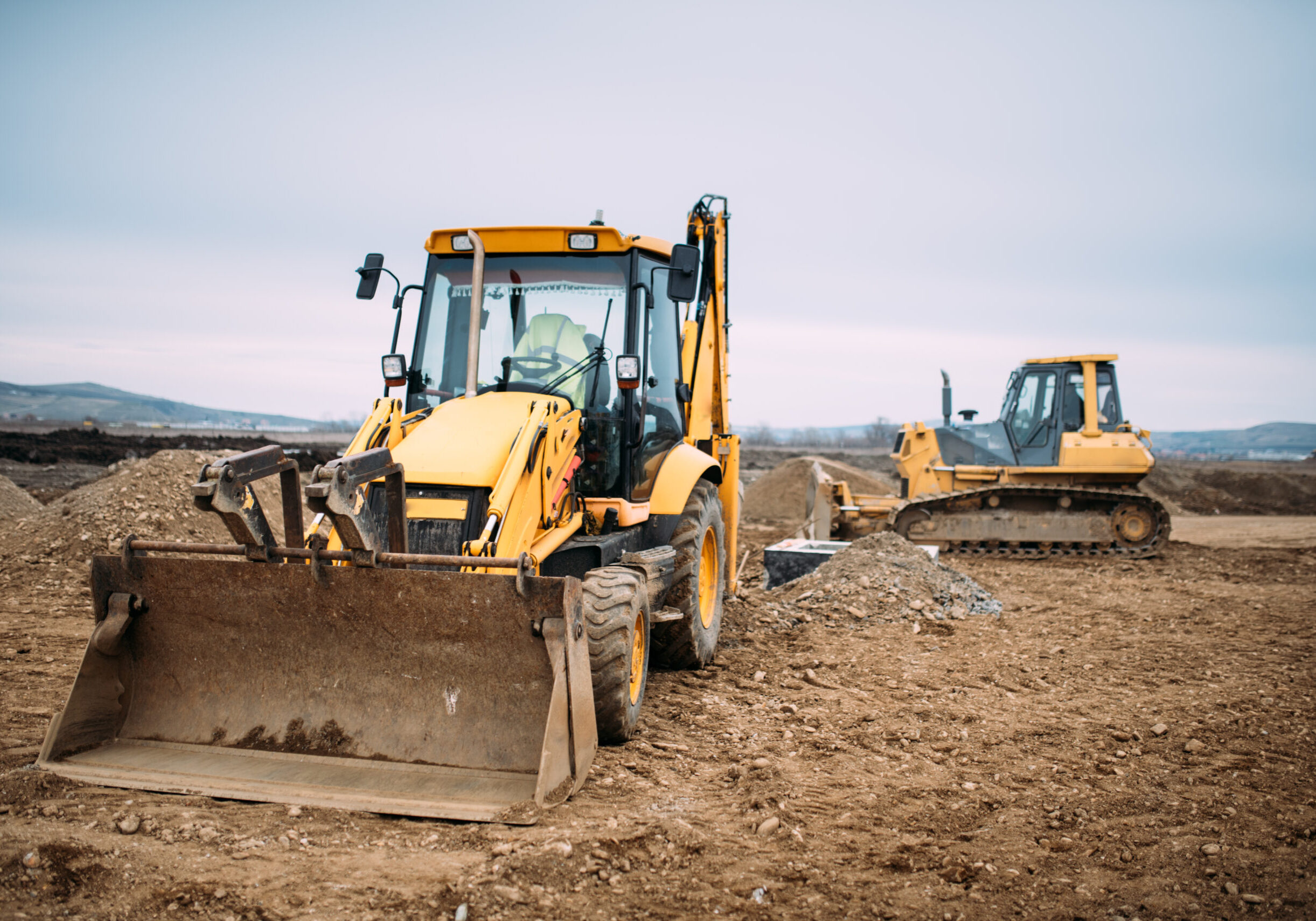 Industrial backhoe excavator loader and bulldozer machinery on construction site